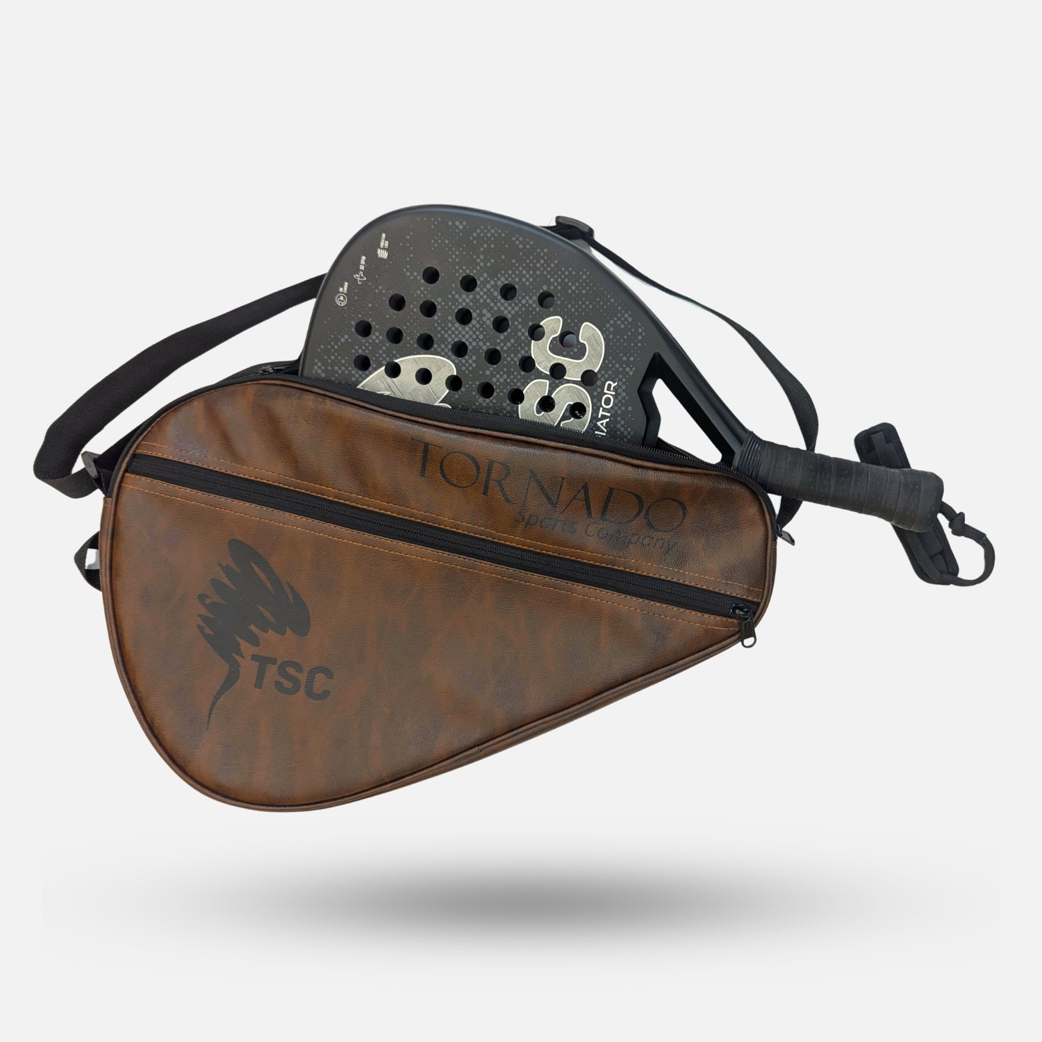 A brown tornado padel tennis racket cover with fly fishing bag with a black shoulder strap, shown floating against a light gray background with a TSC-branded diving board propped behind it.