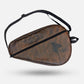 A brown distressed leather Tornado TSC motorcycle shoe bag with a black adjustable shoulder strap, shown floating against a light gray background. padel tennis racket cover