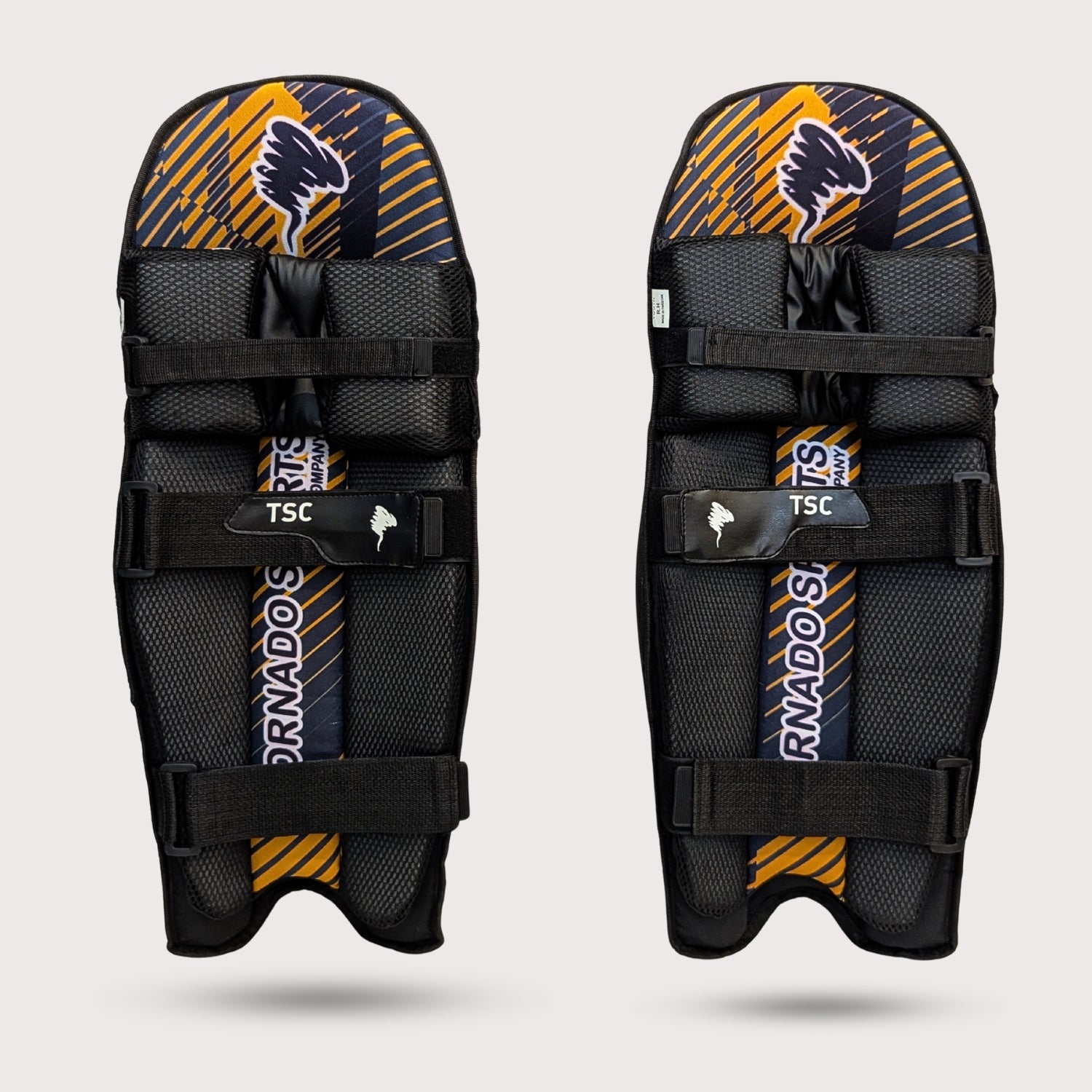 Pair of black and yellow shin guards with 'Tornado' branding on a light gray background cricket molded pads