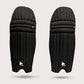 Pair of black protective shin guards on a light gray background molded cricket pads