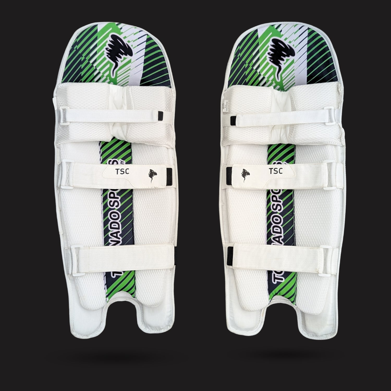 Pair of white cricket leg guards with green and black patterns on a black background