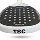 Close-up of a TSC Blade paddle tennis racquet head featuring a black carbon fiber pattern with circular cutouts and white branding text, on a white background.